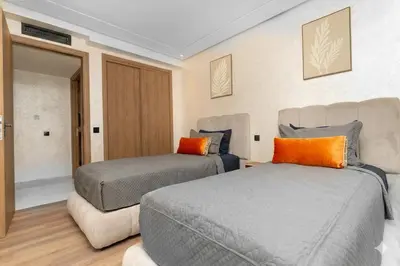 a bedroom with two beds and a couch at Home Holiday pool-Guéliz, Marrakech in Marrakech