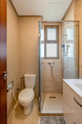 a bathroom with a toilet and a shower and a sink at Prestigia Jubaea Apartment Green Escape & Pool in Marrakech