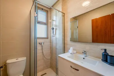 a bathroom with a shower and a toilet and a sink at Prestigia Jubaea Apartment Green Escape & Pool in Marrakech