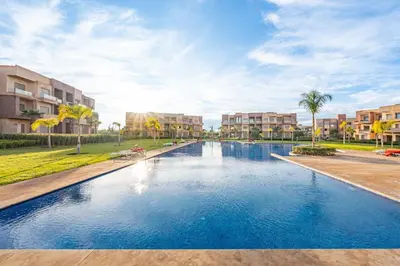 a large swimming pool in front of some apartment buildings at Prestigia Jubaea Apartment Green Escape & Pool in Marrakech