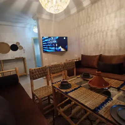 a living room with a couch and a table at Dolce appartement proche de l'aéroport in Marrakech