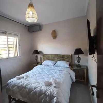 a bedroom with a large bed with white sheets and pillows at Dolce appartement proche de l'aéroport in Marrakech