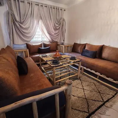 a living room with a couch and a table at Dolce appartement proche de l'aéroport in Marrakech