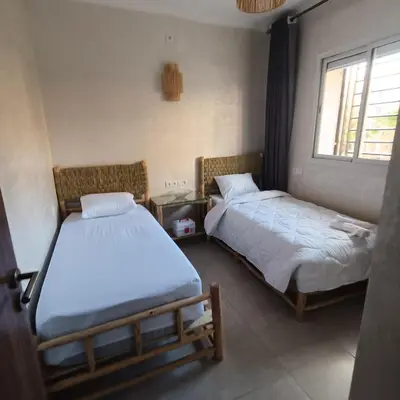 a room with two beds and a window at Dolce appartement proche de l'aéroport in Marrakech