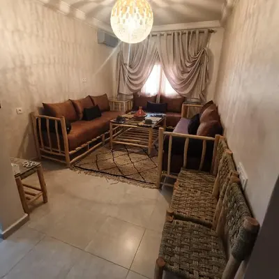 a living room with a couch and a table at Dolce appartement proche de l'aéroport in Marrakech
