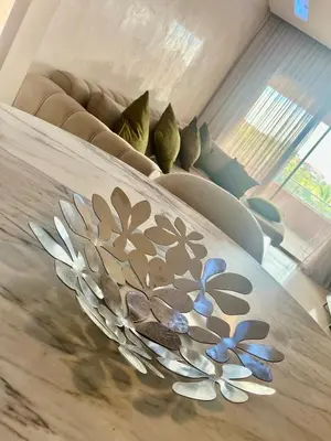 a table with a glass plate with flowers on it at Marrakech Prestigia Center Pool View 3 Bedrooms in Marrakech