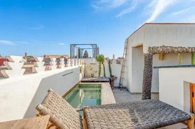 a balcony with chairs and a swimming pool on a building at Riad Imani-Gorgeous Sunny Terrace Breakfast Pool in Marrakech