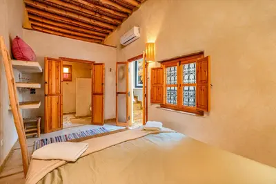 a bedroom with a bed in a room with windows at Riad Imani-Gorgeous Sunny Terrace Breakfast Pool in Marrakech