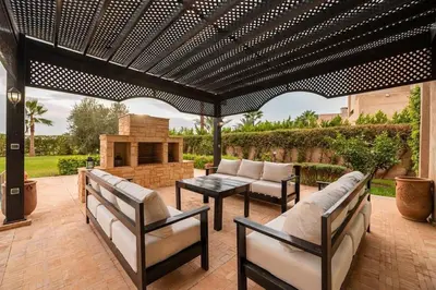 a patio with couches and a table and a fireplace at Luxury Villa Inspired by Authentic Moroccan Design in Marrakech