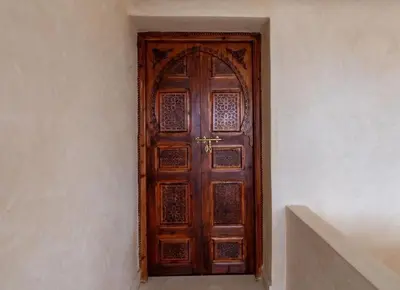 a wooden door in a room with a staircase at Luxury Villa Inspired by Authentic Moroccan Design in Marrakech