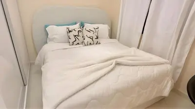a small bed with white sheets and pillows at Luxury Family Apartment in Gueliz in Marrakech