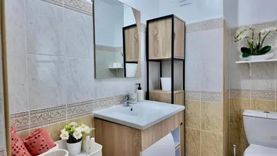 a bathroom with a sink and a mirror and a toilet at Luxury Family Apartment in Gueliz in Marrakech