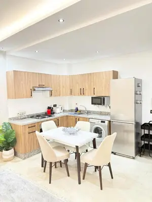 a kitchen with a table and chairs and a refrigerator at Elegant apartment with pool, highly desirable area in Marrakech