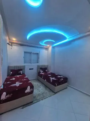 two beds in a room with a blue ceiling at Appartement Marrakech in Marrakech