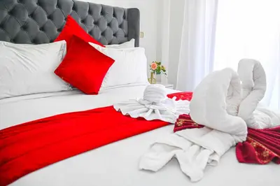 a bed with red and white blankets and pillows at Cosy appartement en plein cœur de Marrakech ! in Marrakech