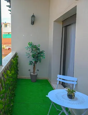 a balcony with a table and a potted plant at Cosy appartement en plein cœur de Marrakech ! in Marrakech