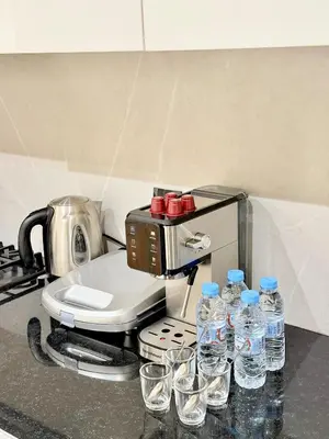 a coffee maker with glasses of water on a counter at Modern apartment with jacuzzi & gym in Marrakech