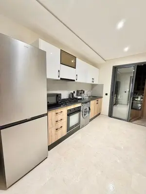 a kitchen with white cabinets and a stainless steel refrigerator at Modern apartment with jacuzzi & gym in Marrakech