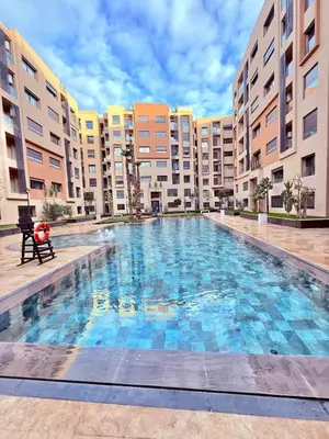 a large swimming pool in front of some apartment buildings at Modern apartment with jacuzzi & gym in Marrakech