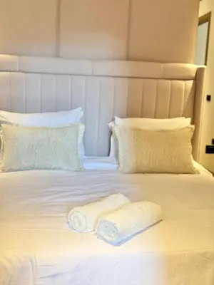 a white bed with two towels on top of it at Apartment with pool & gym in Marrakech