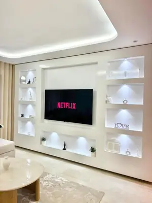 a living room with a tv on a wall at Apartment with pool & gym in Marrakech