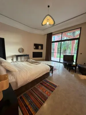 a bedroom with a large bed and a living room at Royal Moroccan House in Marrakech