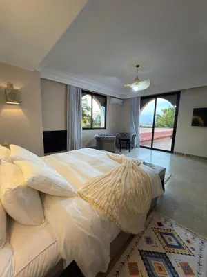 a bedroom with a large bed and a large window at Royal Moroccan House in Marrakech