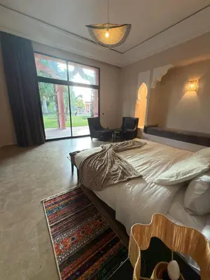 a bedroom with a large bed with two chairs and a desk at Royal Moroccan House in Marrakech