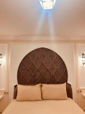 a bedroom with a bed with a large headboard at Le cocon Majorelle in Marrakech
