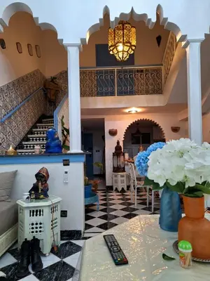 a living room with a staircase and a table at Riad Tanina Rooftop Central Authentic Moroccan Experience in Marrakech