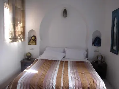 a bedroom with a large bed in a white room at Riad Tanina Rooftop Central Authentic Moroccan Experience in Marrakech