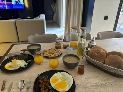 a breakfast table with eggs and bread and orange juice at Modern marrakech duplex in Marrakech