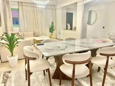 a dining room with a marble table and chairs at Azou Luxury apartment - Pool & Garden Marrakech in Marrakech