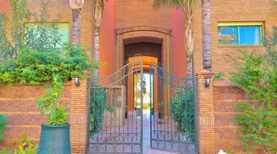 an entrance to a brick house with an iron gate at Azou Luxury apartment - Pool & Garden Marrakech in Marrakech