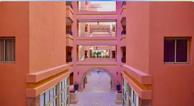 an empty hallway in a building with pink walls at Azou Luxury apartment - Pool & Garden Marrakech in Marrakech