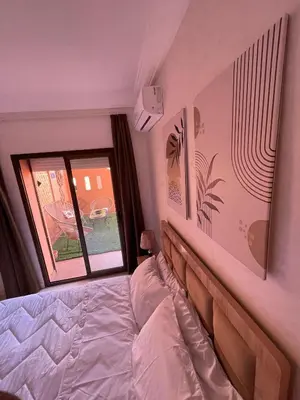 a bedroom with a bed and a window at Appartement Nature et design in Marrakech