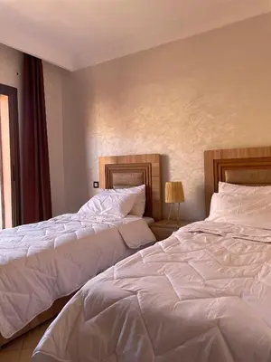 two beds sitting next to each other in a bedroom at Appartement Nature et design in Marrakech