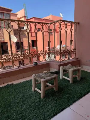 two benches on a balcony with a fence at Appartement Nature et design in Marrakech