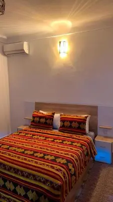 a bedroom with a bed with a colorful blanket on it at Appartement near to big square in Marrakech