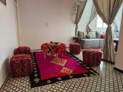 a living room with a red table and two chairs at Appartement near to big square in Marrakech