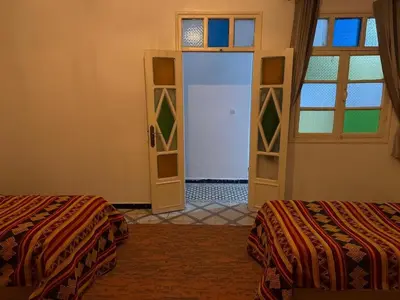 a room with two beds and an open door at Appartement near to big square in Marrakech