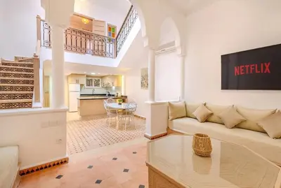 a living room with a couch and a kitchen at Riad melyssa in Marrakech