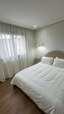 a bedroom with a large white bed and a window at High standing 2 minutes from Gueliz train station in Marrakech