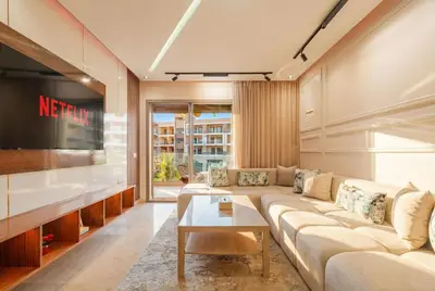 a living room with a couch and a tv at Séjour luxueux pearl garden Marrakech in Marrakech