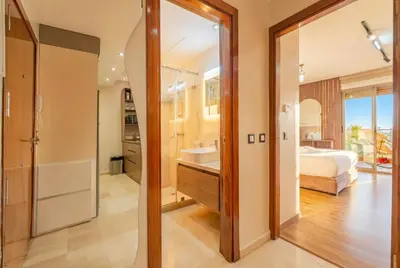 a bedroom with a bed and a bathroom with a sink at Séjour luxueux pearl garden Marrakech in Marrakech