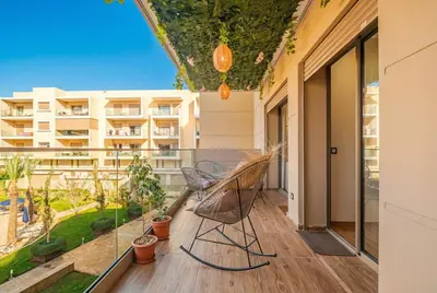 an apartment balcony with a chair and a view of a building at Séjour luxueux pearl garden Marrakech in Marrakech