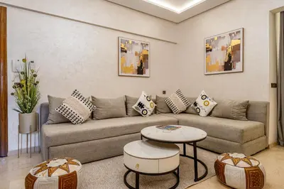 a living room with a couch and a table at Beautiful apartment in residence with pool in Marrakech