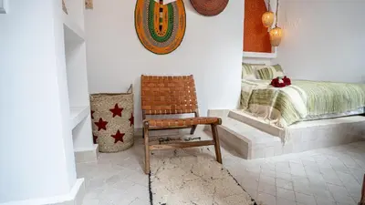 a bedroom with a bed and a wooden chair at Riad Lala Fatima - New & Exclusive - Pool & Breakfast in Marrakech