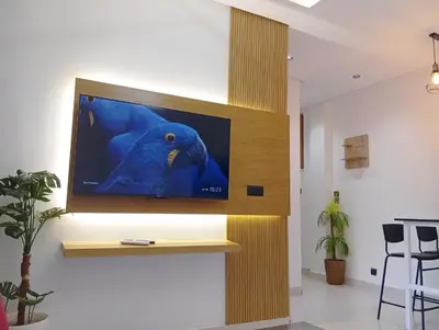 a tv on a wall with a blue bird on it at Perle de Guéliz Marrakech in Marrakech