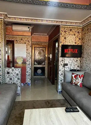 a living room with a couch and a tv at Apartment in Bassatine targa in Marrakech